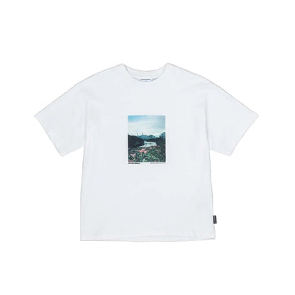 White t-shirt with a small graphic on a gray background