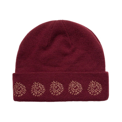 Maroon beanie with sunburst patterns on a white background
